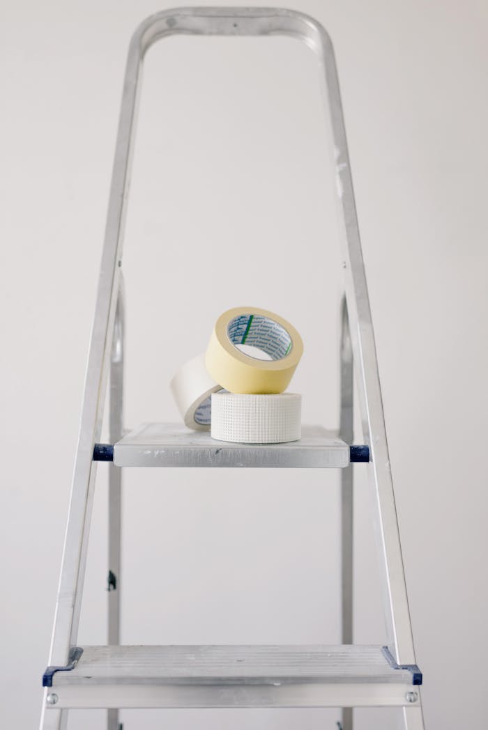 creative-02 Metal stepladder with rolls of tape for home renovation projects.